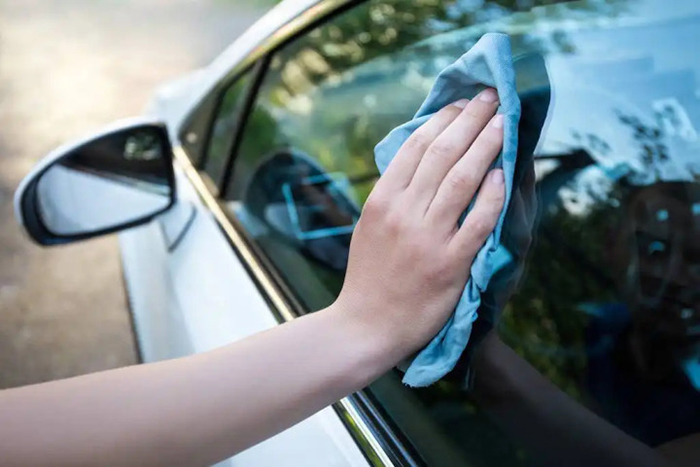 Dùng khăn sạch lau cửa kính bên ngoài xe ô tô